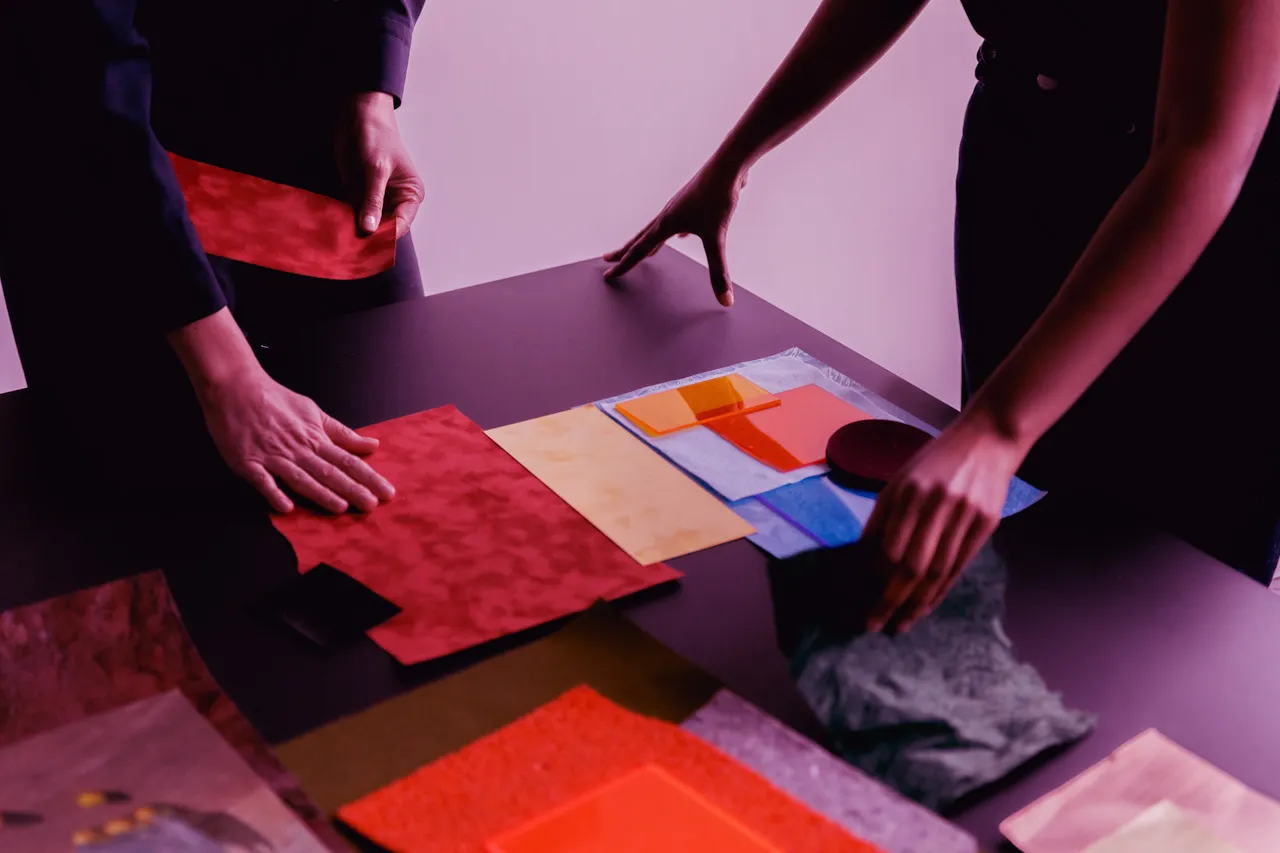 Hands placing colored materials on a planning table